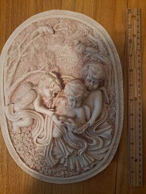 Detailed resin wall plaque with a three-cherub relief design. This off-white dec